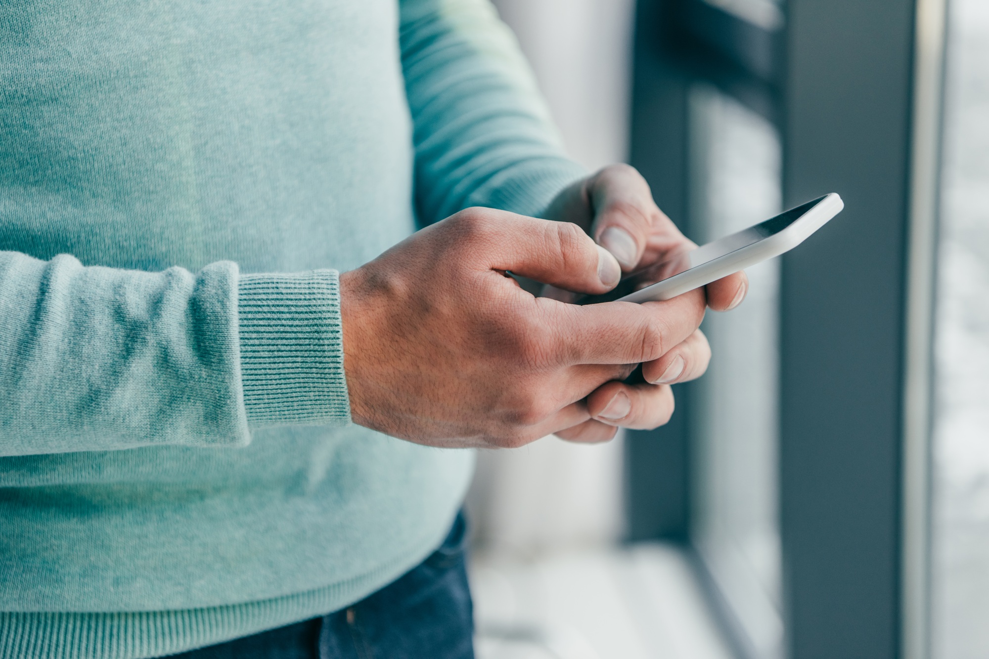 cropped view of man holding smartphone in hands