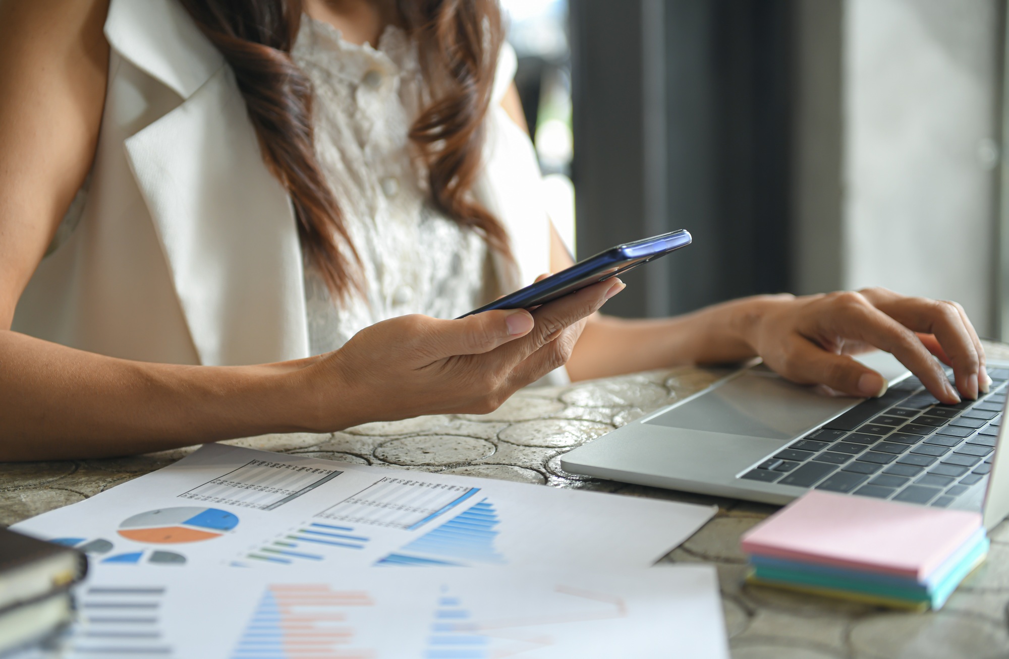Hand of a business woman is using a mobile phone to find information.