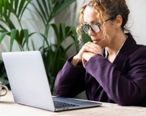 Professional entrepreneur reading email on laptop at the desk wearing glasses