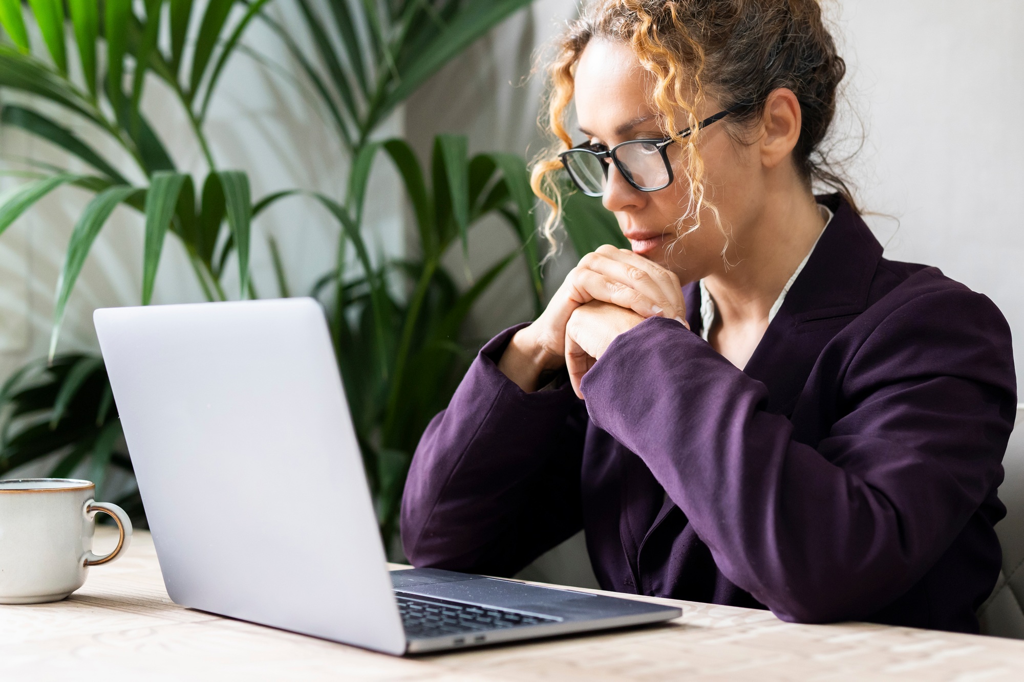 Professional entrepreneur reading email on laptop at the desk wearing glasses