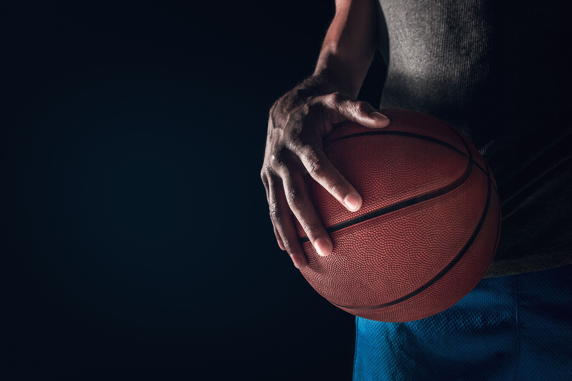 The hands of a basketball player with ball
