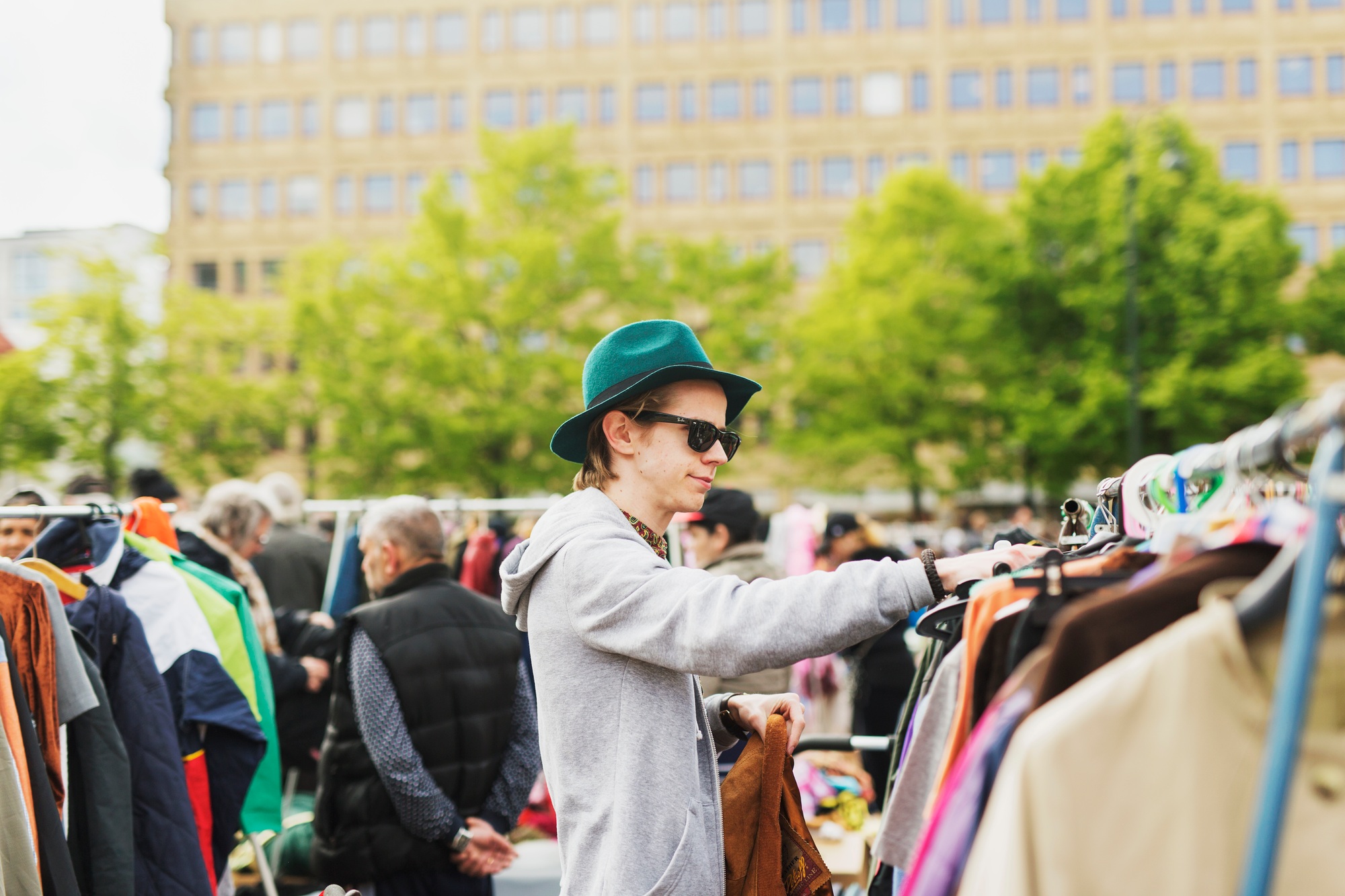 Young man wearing sunglasses and hat shopping at flea market